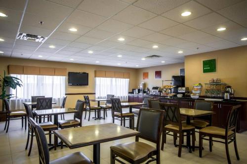 ein Esszimmer mit Tischen und Stühlen und einem Fernseher in der Unterkunft Comfort Inn & Suites Augusta Fort Gordon Area in Augusta