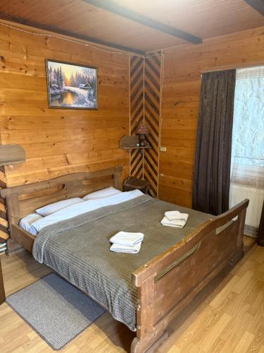 a bedroom with a bed in a wooden room at Kabanova Gora in Bukovel