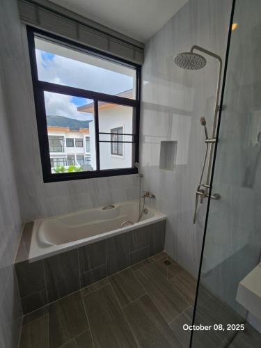 a bathroom with a bath tub and a window at Goldena Residence Pool Villas in Kamala Beach