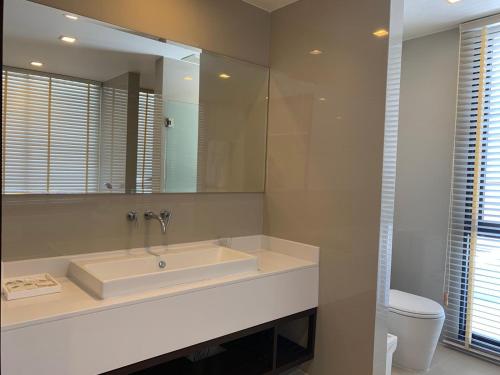 ein Badezimmer mit Waschbecken und großem Spiegel in der Unterkunft Laguna Parkside 5 bedroom villa with pool near the beach in Laguna Phuket