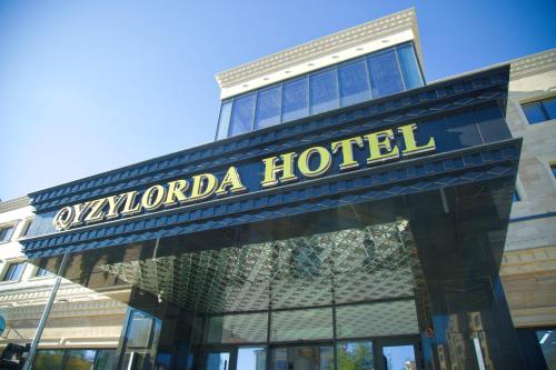 a hotel sign in front of a building at Qyzylorda Hotel in Kyzylorda