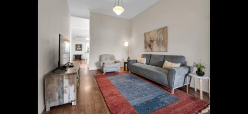 a living room with a couch and a tv at Tompson Apartment in Wagga Wagga