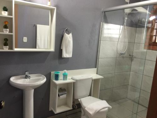 une salle de bains avec douche, toilettes et lavabo dans l'établissement Residencial Quatro Estações, à Canela