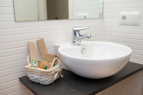 a bathroom with a sink and two baskets on a counter at Mimoses Apartaments in Cadaqués