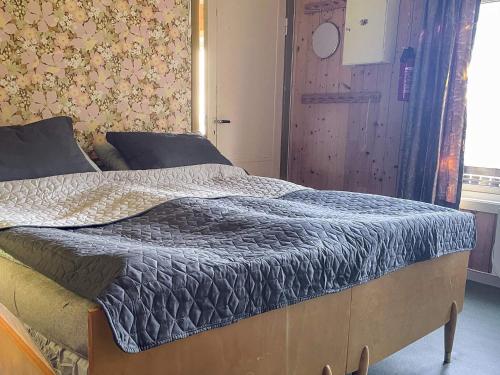 a bed with a blue comforter in a bedroom at 3 person holiday home in Frei-By Traum in Frei