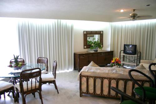 a living room with a bed and a table and chairs at Hotel Suites Jazmín Acapulco in Acapulco