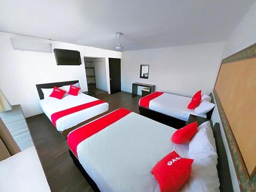 a room with three beds with red pillows at OYO Hotel Plata,Fresnillo, Zacatecas in Fresnillo de González Echeverría