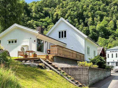 a white house on a hill with a wooden deck at 8 person holiday home in Lindesnes in Tryland