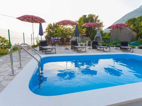 a swimming pool with tables and umbrellas on a resort at Villa in Tučepi with Pool near Seabeach in Tučepi