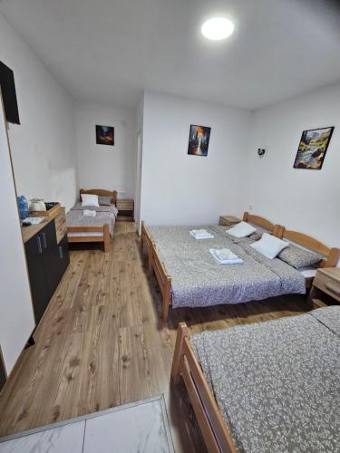 a room with two beds in a room with wooden floors at Zolax Apartmans in Mali Iđoš