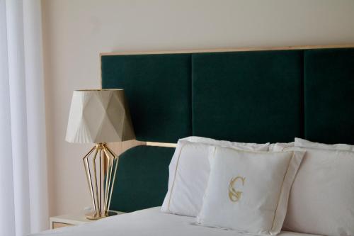 a bed with a green headboard and white pillows at Green Gold Passion in Santo Estêvão