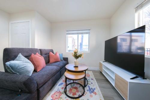 Una sala de estar con un sofá y un televisor de pantalla plana. en Modern Luxe Ensuite by USC Shared Living, en Los Ángeles