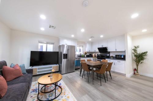 a living room with a couch and a table and a kitchen at Modern Luxe Ensuite by USC Shared Living in Los Angeles