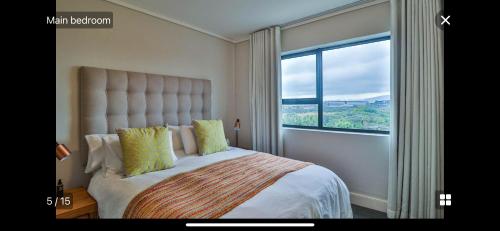 a bedroom with a large bed with a large window at Waters Edge Sanctuary in Cape Town