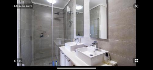 a bathroom with a sink and a shower with a mirror at Waters Edge Sanctuary in Cape Town
