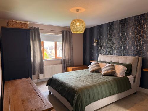 a bedroom with a bed with a blue wall at Foyleview Point in Balnacart