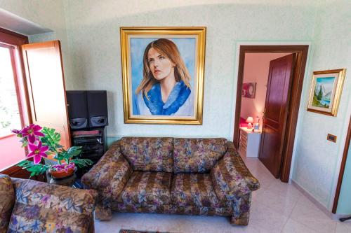 a living room with a couch and a painting of a woman at L'Aurora Viola in Carbonia