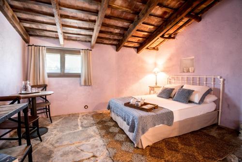 een slaapkamer met een bed, een tafel en een bureau bij Estança La Pau - Adults Only in Mallá