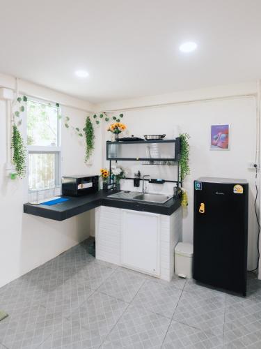 a kitchen with a sink and a black refrigerator at Free Netflix 3BR 10 Mins to City Center 3 Mins 7-11 in Hat Yai