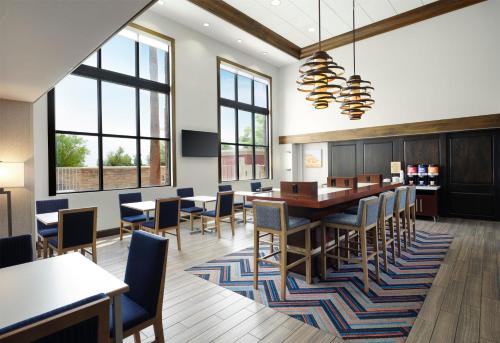 a dining room with a table and chairs and windows at Hampton Inn & Suites Las Vegas-Red Rock/Summerlin in Las Vegas