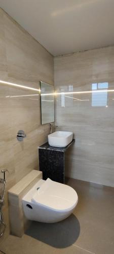 a bathroom with a white toilet and a sink at Eco Wind in Lonavala