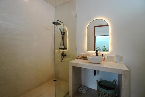 タナロットにある'Villa Vivid' 2BR Bohemian, 5 min to Kedungu Beachの洗面台、鏡、シャワー付きのバスルーム