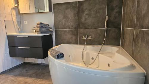 a white bath tub in a bathroom with a counter at Kapitänshus-Strandpark 24 in Grömitz