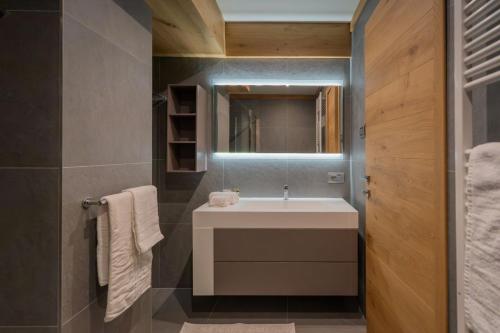 une salle de bain avec un lavabo et un miroir dans l'établissement MAISON DI VOLPI - Il fascino della montagna, la comodità del centro, à Courmayeur