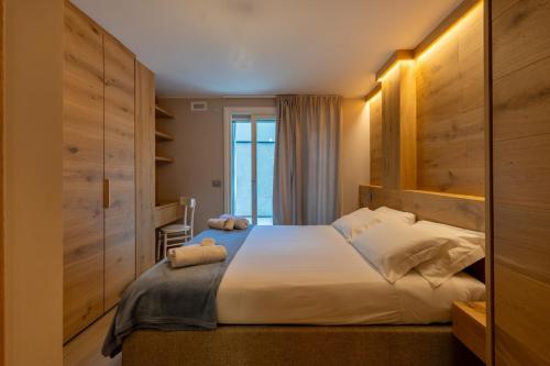 une chambre avec un grand lit et une fenêtre dans l'établissement MAISON DI VOLPI - Il fascino della montagna, la comodità del centro, à Courmayeur