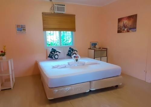 プエルト・プリンセサにあるB&R Hostelの窓のある部屋にある大きな白いベッド