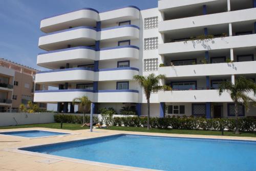 an apartment building with a swimming pool in front of it at Timeless Vacations Vilamoura Marina Flat WIFI & Pool in Vilamoura