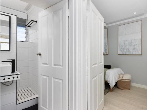 a white bathroom with a shower and a white door at Sandy Shores On Beach - 709 in Strand
