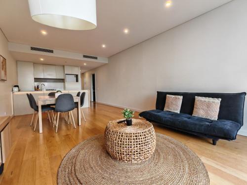 a living room with a couch and a table at 2BR apt close to MQ shopping centre and university in Sydney