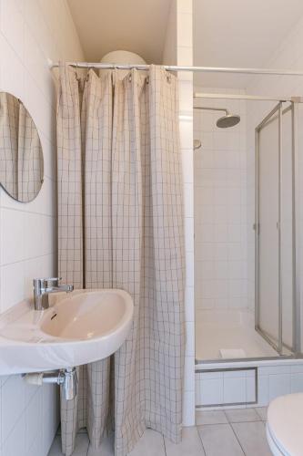 a bathroom with a sink and a shower at Seahouse by BLOSS, appartement met magistraal zeezicht met 2 terrassen in Wenduine