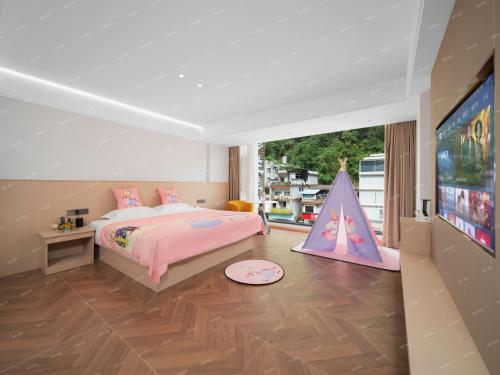 Una habitación con una cama rosa y una tienda de campaña de juegos en Ban Shan Du Hotel, en Yangshuo