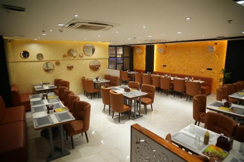 a dining room with tables and chairs in a restaurant at Hotel Devki Inn in Gorakhpur