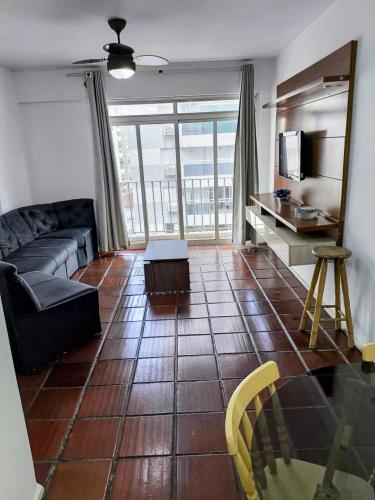 ein Wohnzimmer mit Sofa und Tisch in der Unterkunft Apartamento Guarujá in Guarujá