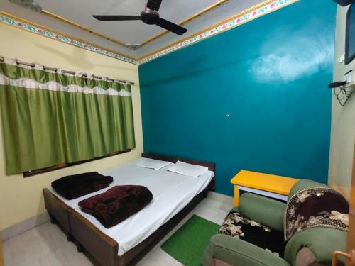 a bedroom with a bed and a blue wall at Hotel Shanti rest house - शांति विश्राम गृह Gaya in Gaya