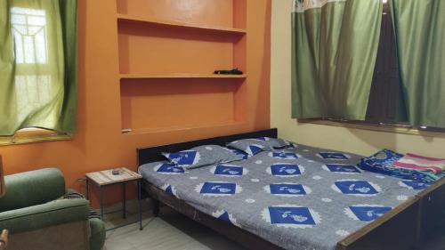 a bedroom with a bed with blue pillows on it at Hotel Shanti rest house - शांति विश्राम गृह Gaya in Gaya