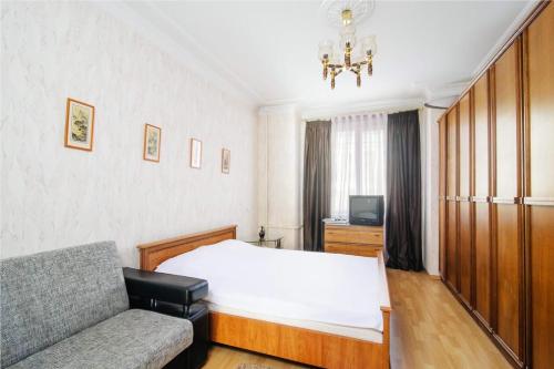 1 dormitorio con cama, sofá y TV en Economy Apartment Center, en Minsk