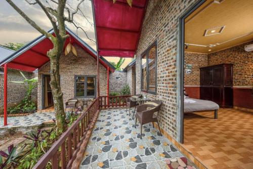 a room with a balcony with a bed and a tree at Cat Ba Spring Homestay in Cat Ba