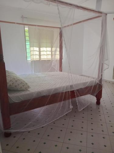 a bedroom with a bed with a mosquito net at Dannys&nickson holiday homes in Watamu