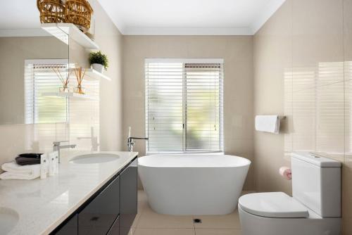 Un baño con bañera, inodoro y lavabo. en 15 Nairana Rest Noosa Heads, en Noosa Heads