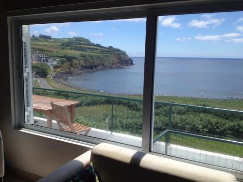 a view of the ocean from a living room window at Sea Bay House in Lagoa