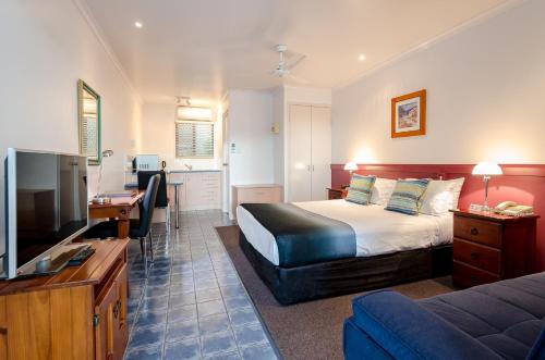 um quarto de hotel com uma cama e uma televisão de ecrã plano em Central Studio Accommodation em Gladstone