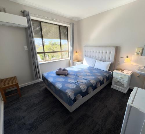 a small bedroom with a bed and a window at Tailem Bend Riverside Hotel in Tailem Bend