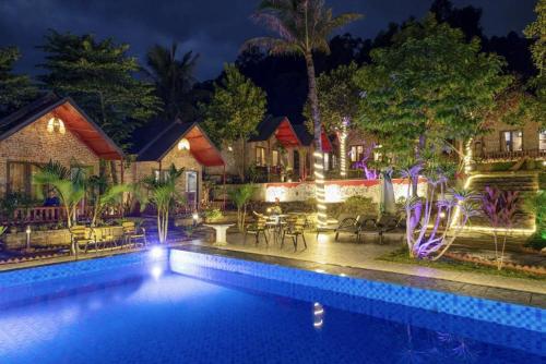 a house with a swimming pool at night at Cat Ba Spring Homestay in Cat Ba