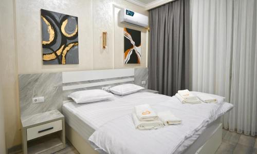 a bedroom with a white bed with towels on it at Bukhara Vavilon Plaza Hotel in Bukhara