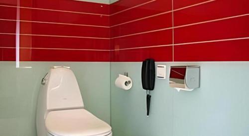 bagno con servizi igienici e telefono appeso al muro di Tomolo Hotel Wuzhan Branch a Wuhan