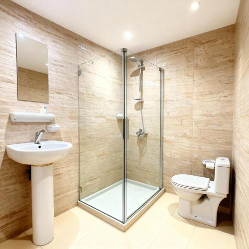 a bathroom with a shower and a toilet and a sink at phoenix Pyramids- roof top in Cairo